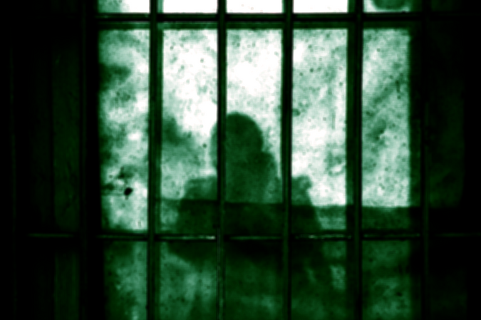 Image of a human shadow behind a cage