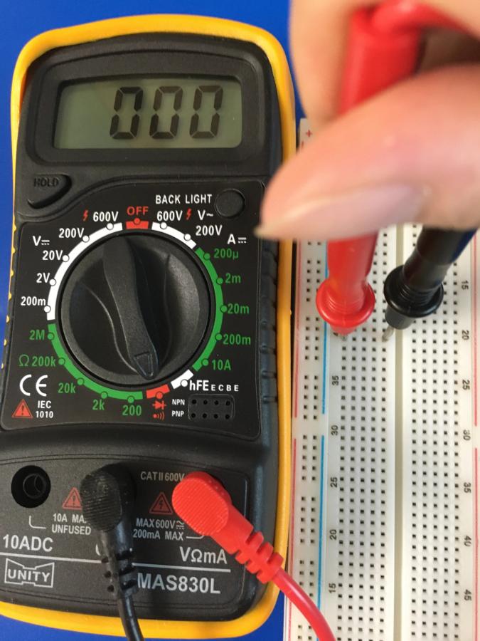 Photo of multimeter testing its probes inside a breadboard