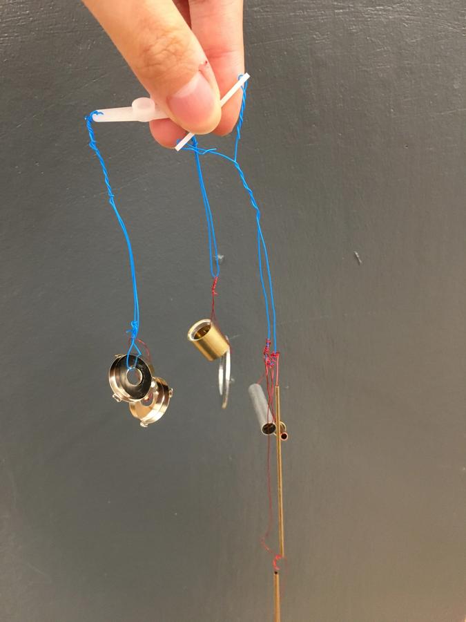 Photo of small metal pieces attached to servo motor wings with wire