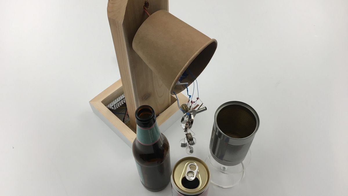 Photo of Sound Branch, an arduino instrument with metal pieces hanging and turning next to bottles