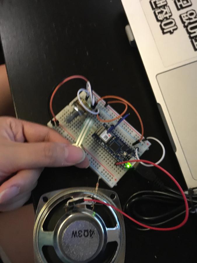Photo of fingers pressing force sensors that is connected to laptop and a speaker via Arduino