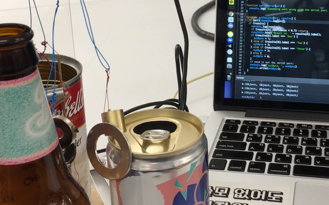 Photo of metal parts hanging and a laptop displaying code to sense voice commands