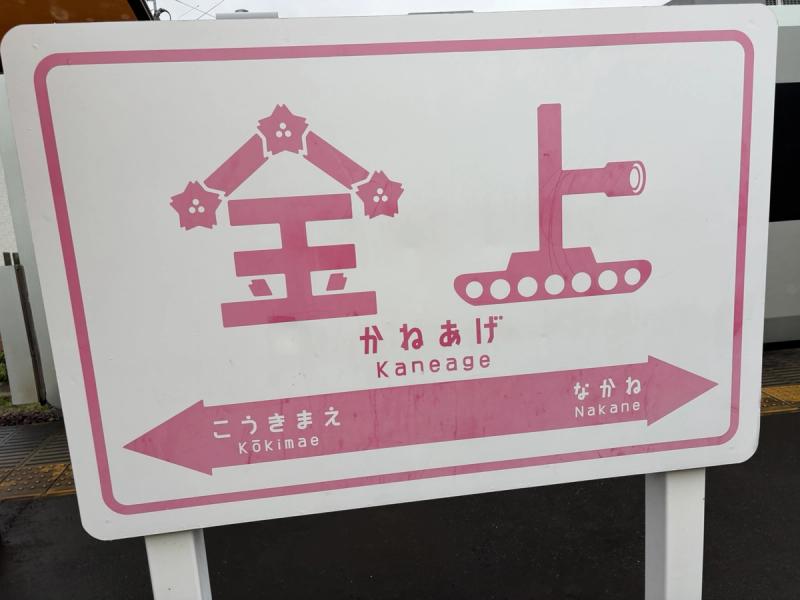 桜と戦車が描かれた金上駅の駅名標