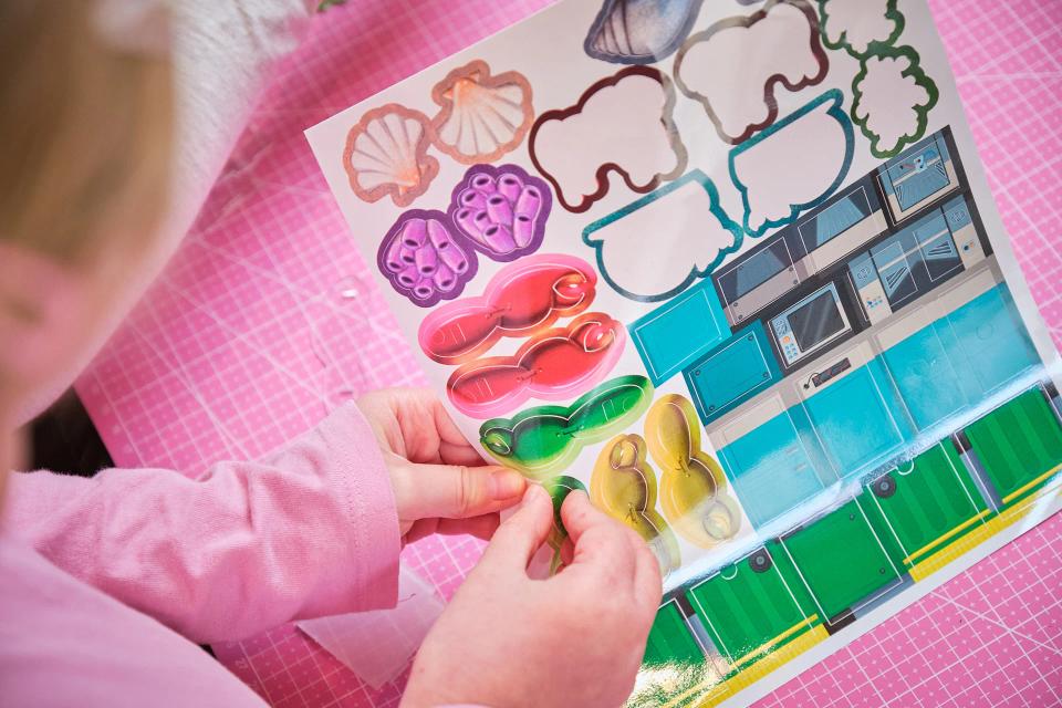 A girl playing with CircuitMess Dusty stickers