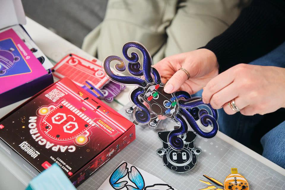 Two people assembling CircuitMess Artemis and Capacitor