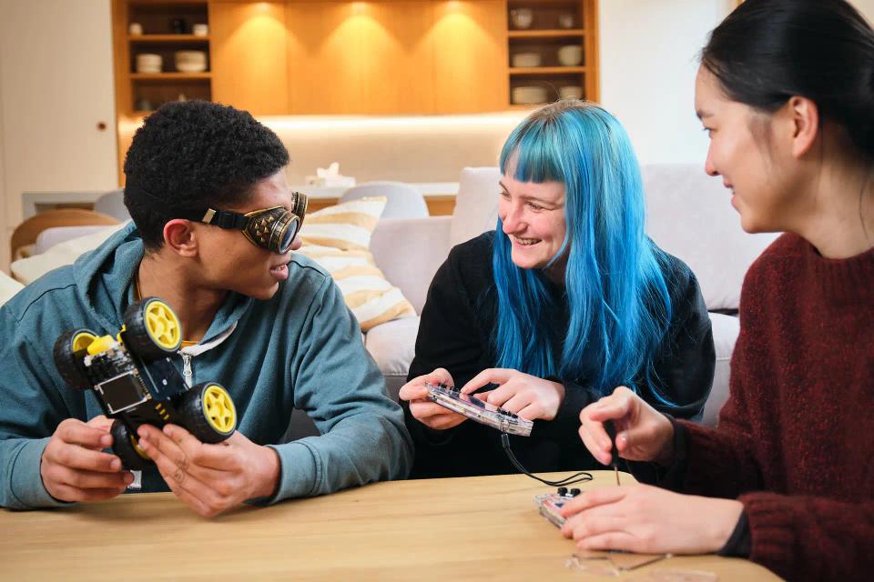 A group of people assembling and playing with CircuitMess Wheelson and ByteBoi