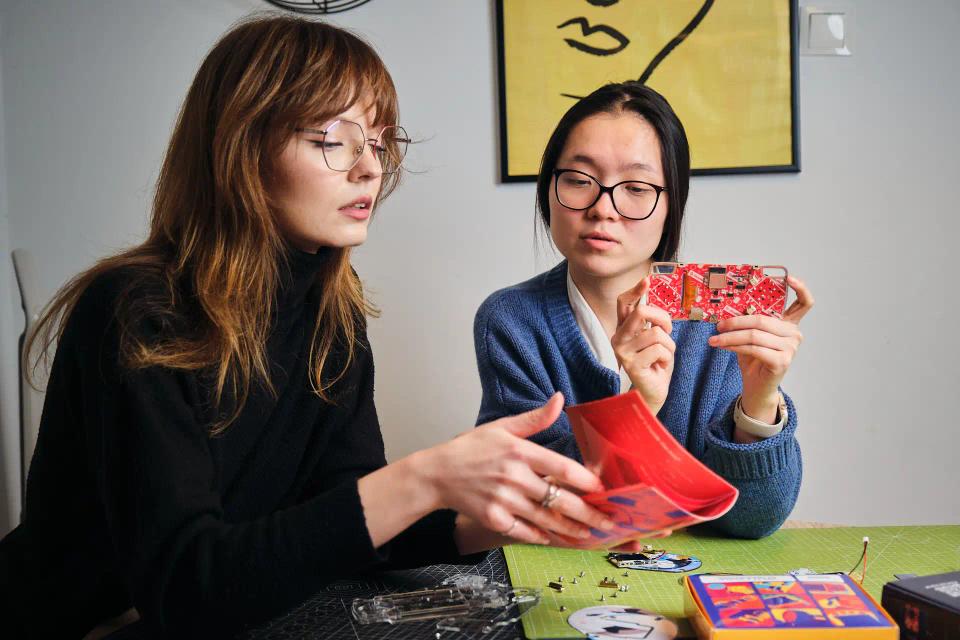 Two girls reading instructions and assembling CircuitMess ByteBoi