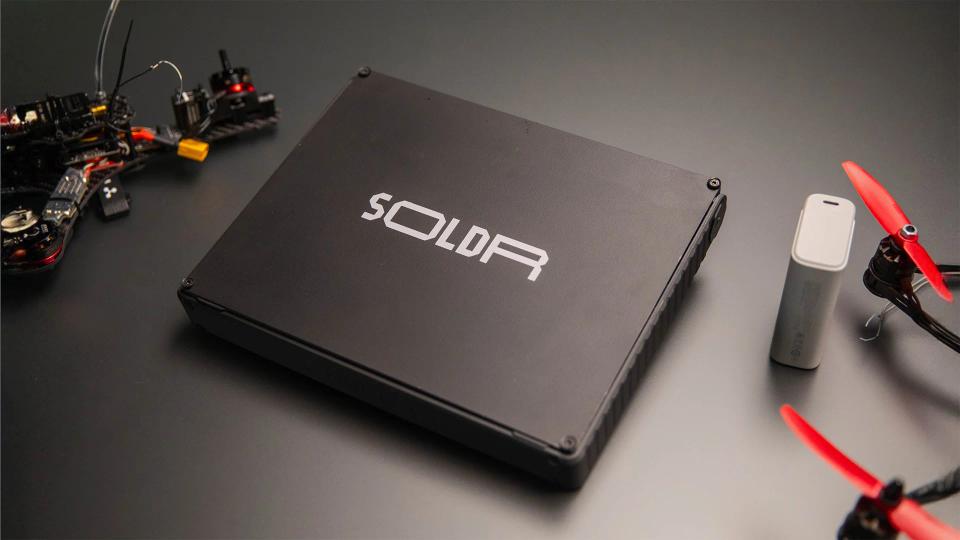 SOLDR Deluxe case on a black table with electronic components around it.