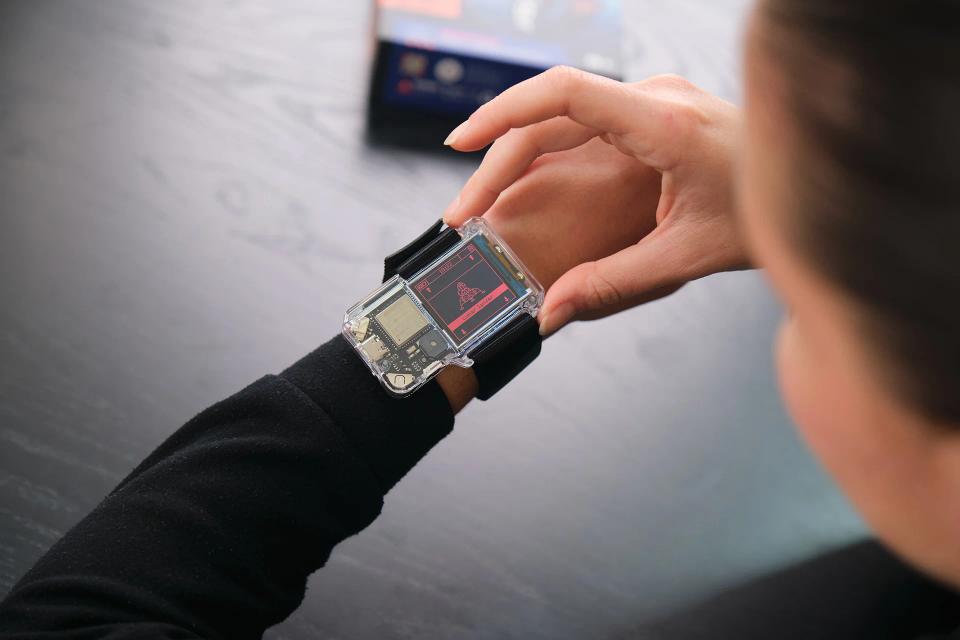 A person pressing buttons on CircuitMess NASA Artemis Watch 2.0.