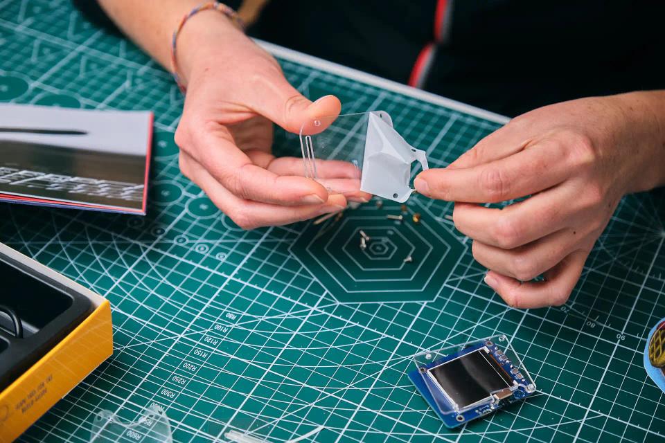 A person assembling CircuitMess Clockstar