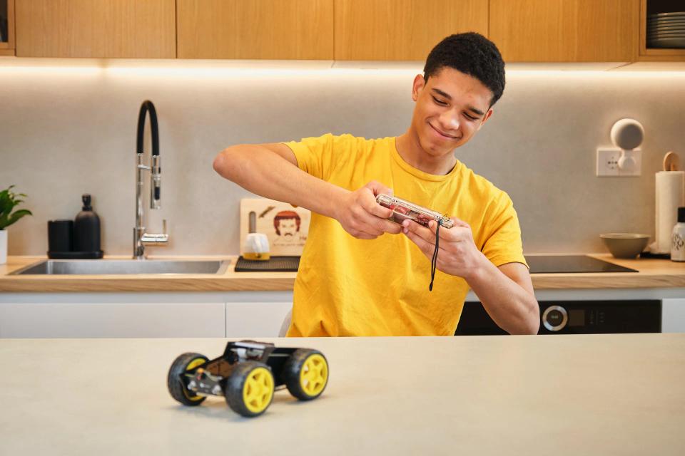 A man controlling CircuitMess Wheelson with ByteBoi