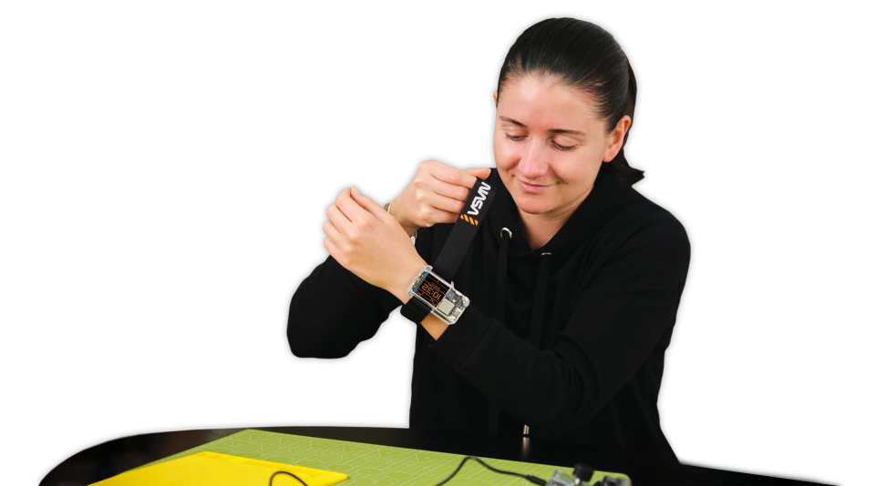 A woman putting on CircuitMess NASA Artemis Watch 2.0 on her hand.