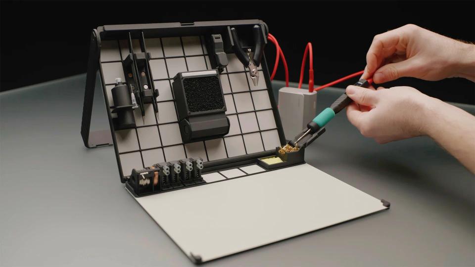 A person using SOLDR Deluxe soldering kit.
