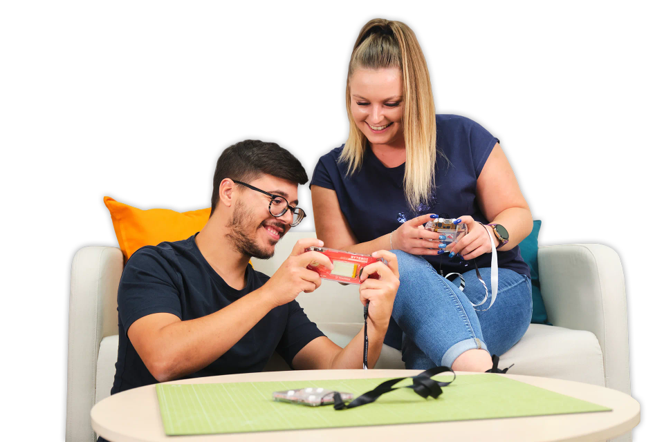 A man and a woman playing with CircuitMess ByteBoi 2.0 and Codee 2.0.