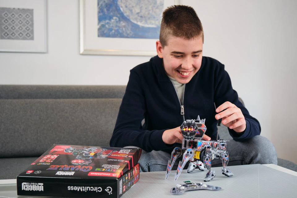 A boy using a screwdriver to assemble CircuitMess Charlie