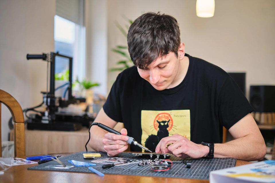 A man using soldering tools to assemble CircuitMess Jay-D