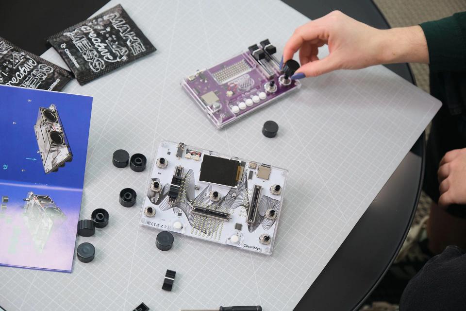 A person assembling CircuitMess Synthia 2.0 and Jay-D 2.0 on a gray work mat.
