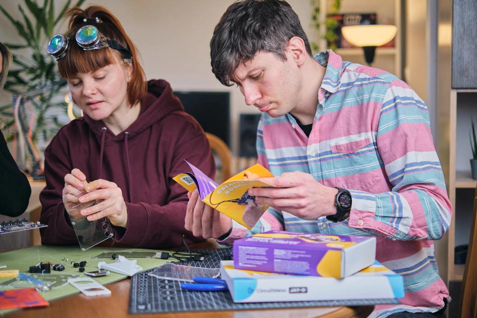 A group of people reading instructions and assembling CircuitMess Jay-D