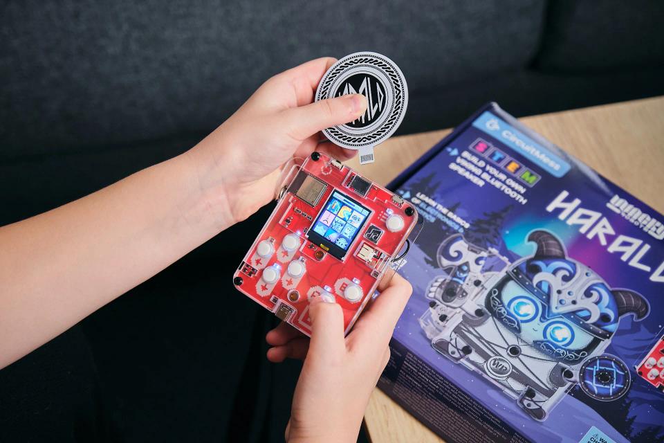 A person putting a Harald game token into CircuitMess Bit console