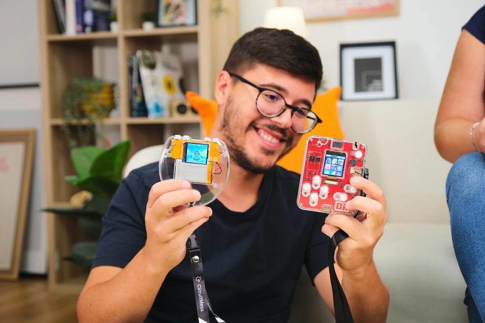 A person holding CircuitMess Bit 2.0 and Codee 2.0