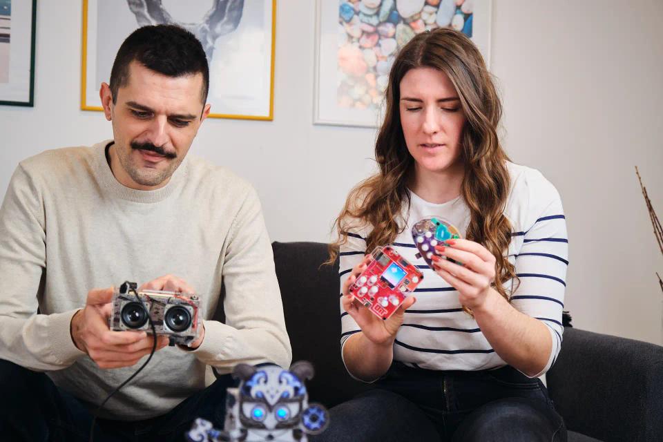 A man and a woman playing with CircuitMess Bit, Harald, Buttons, and Jay-D