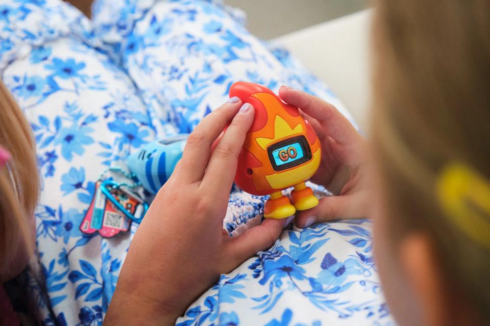 A girl playing with CircuitMess Beep Boop Tochi.