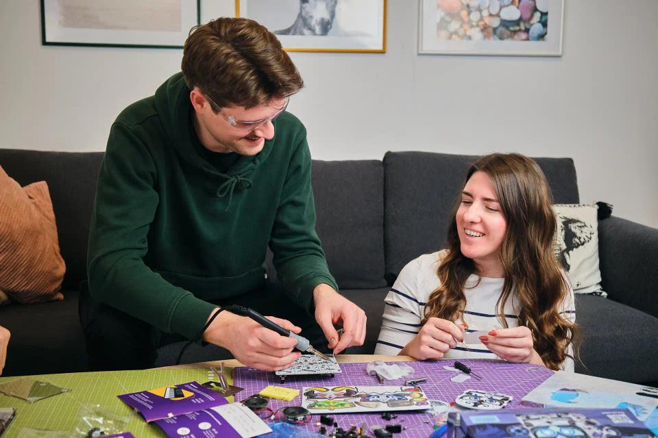 A man and a woman assembling CircuitMess Harald