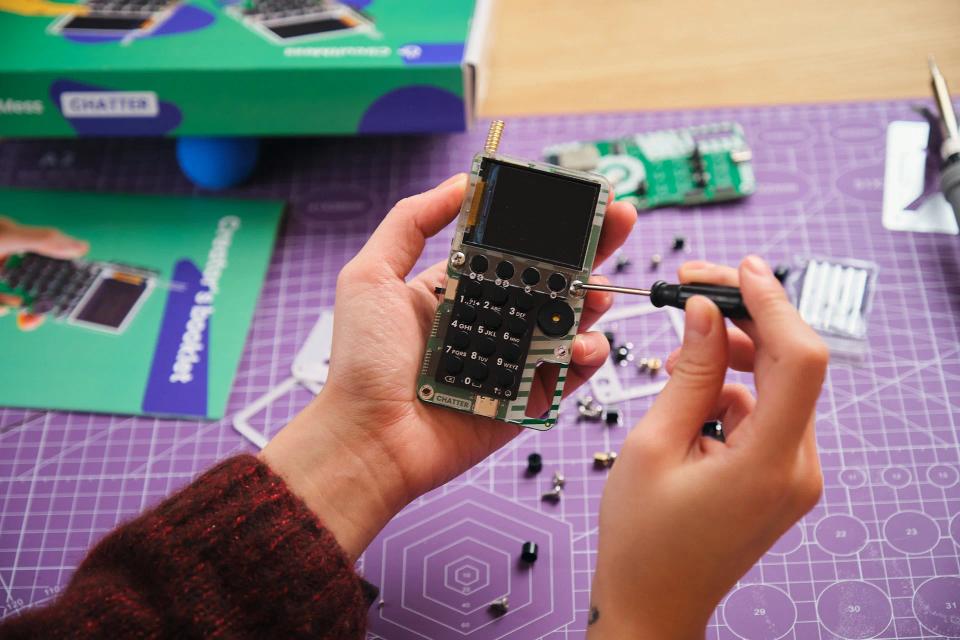 A person using a screwdriver to assemble CircuitMess Chatter