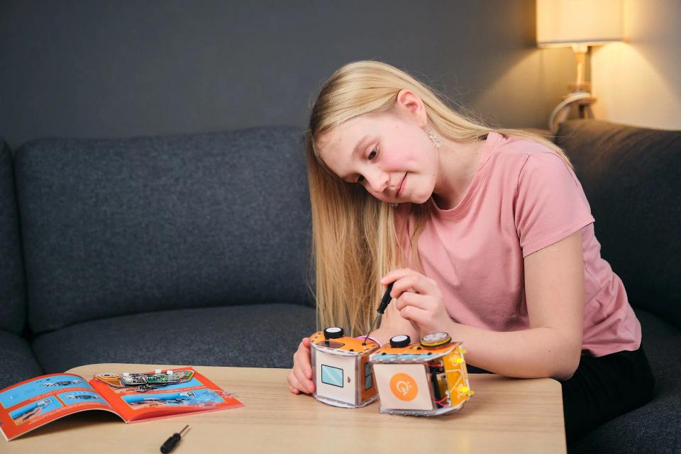 A girl using a screwdriver to assemble CircuitMess Planck