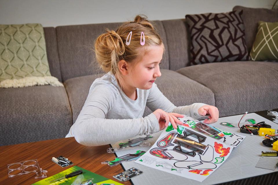 A girl playing with CircuitMess Sparkly stickers