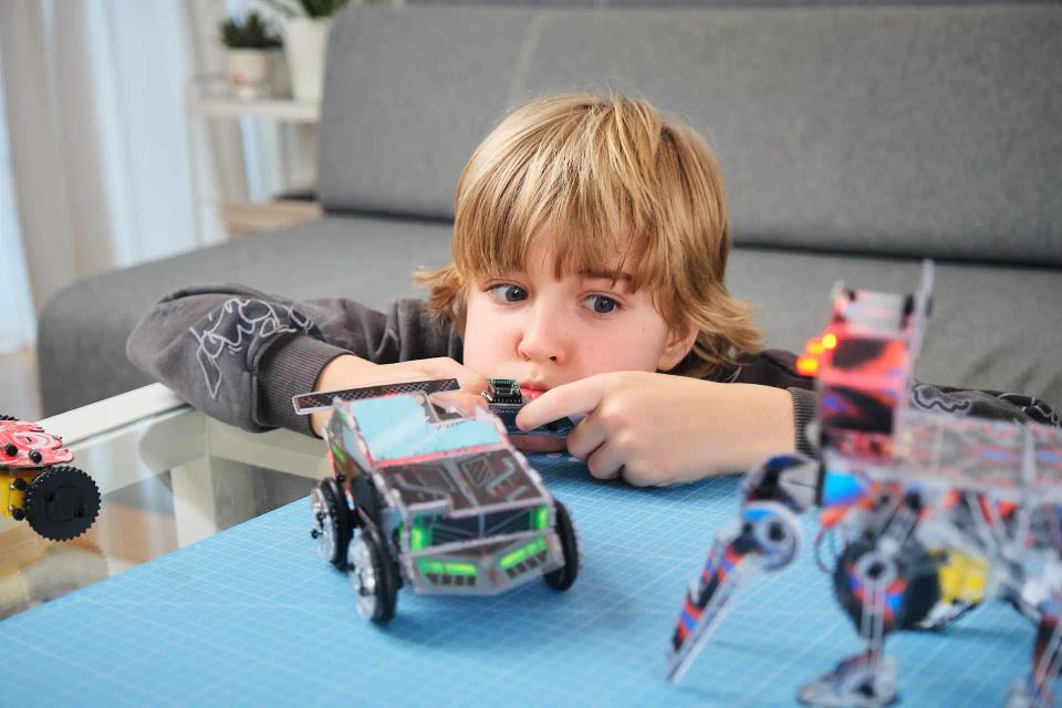 A boy playing with CircuitMess Charlie and Sparkly