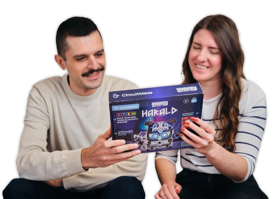 A man and a woman looking at CircuitMess Harald packaging