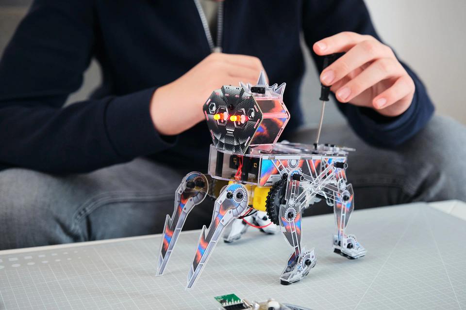 A boy using a screwdriver to assemble CircuitMess Charlie