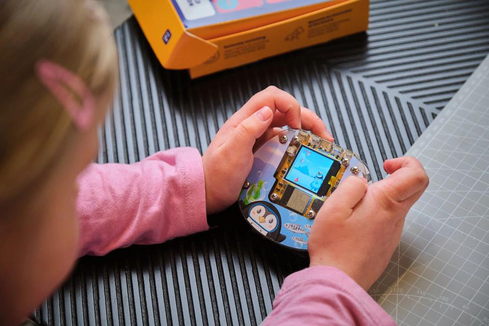 A girl playing games on a CircuitMess Codee