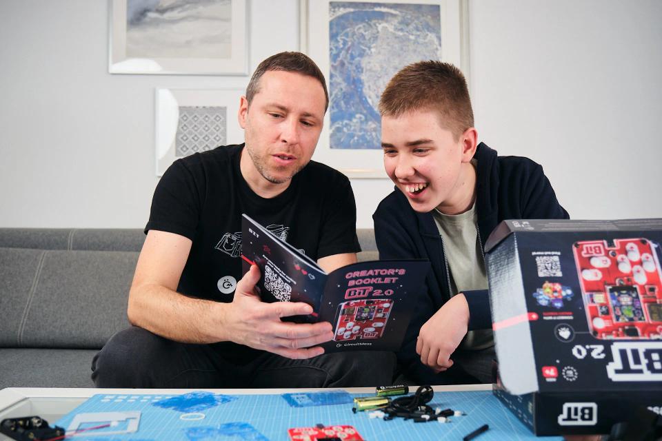 Father and son reading CircuitMess Bit instructions