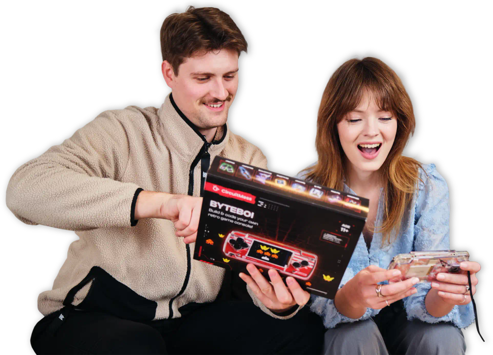 Two people playing with CircuitMess ByteBoi