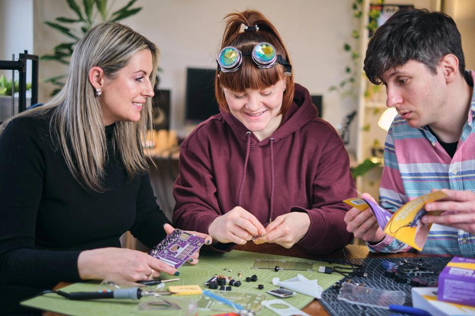 A group of people reading instructions and assembling CircuitMess Synthia