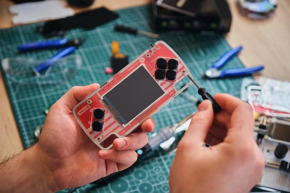 A person using a screwdriver to assemble CircuitMess ByteBoi