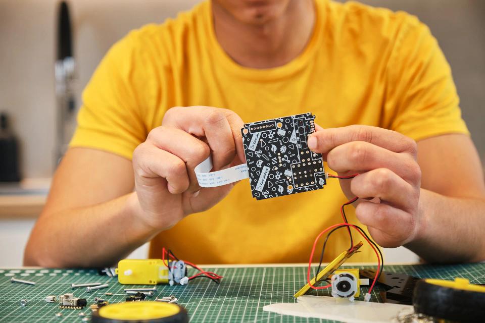A man assembling CircuitMess Wheelson