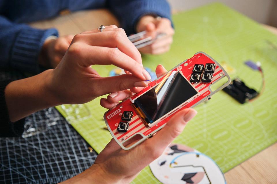 A woman putting screws onto CircuitMess ByteBoi