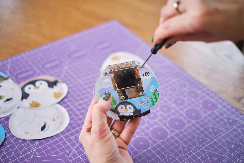 A person using a screwdriver to assemble CircuitMess Codee