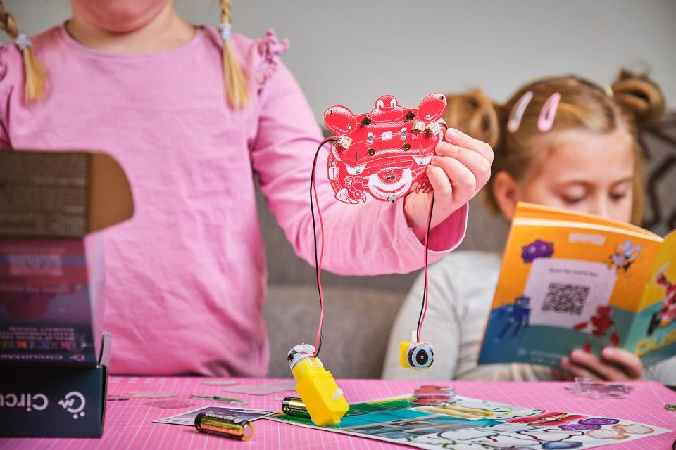 Two girls assembling CircuitMess Dusty and reading instructions