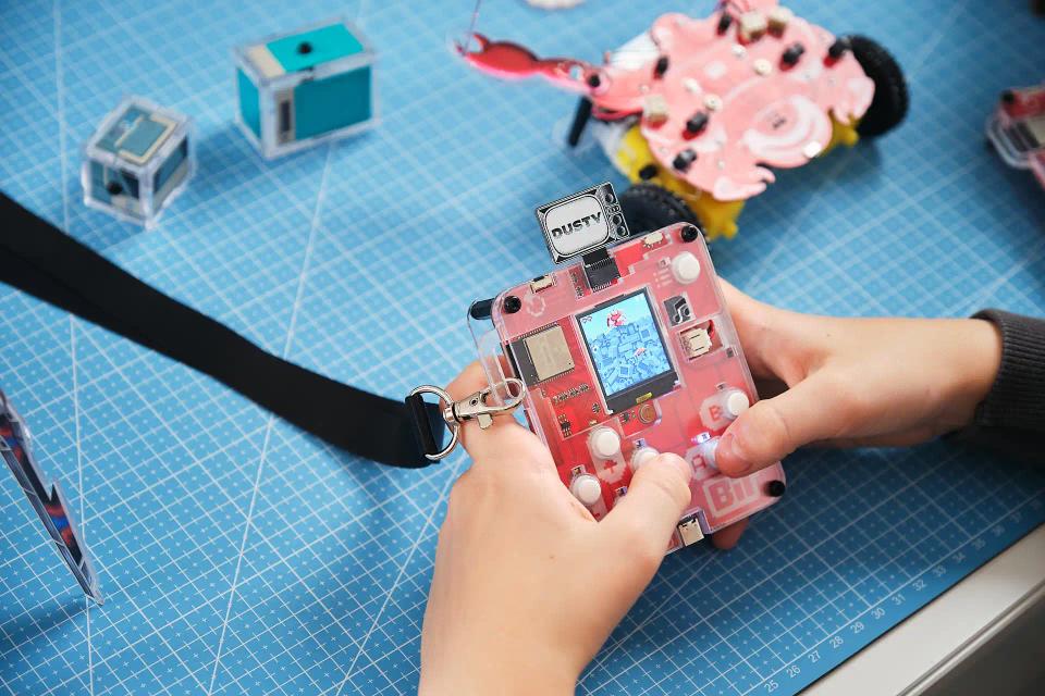 A person playing CircuitMess Bit with a Dusty game token