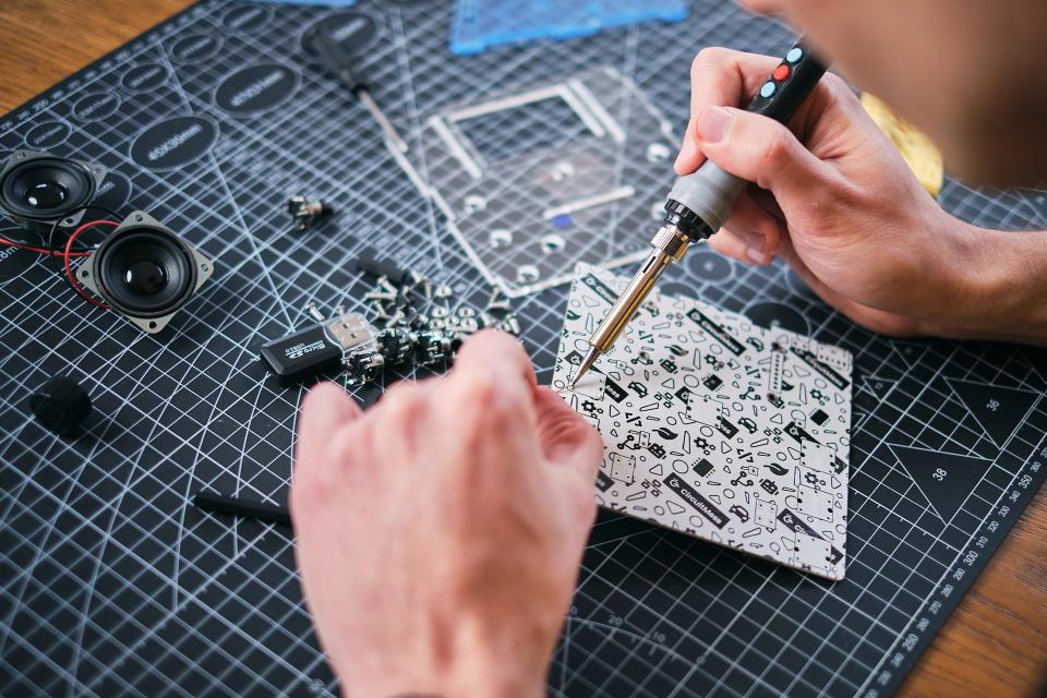 A person using soldering tools to assemble CircuitMess Jay-D