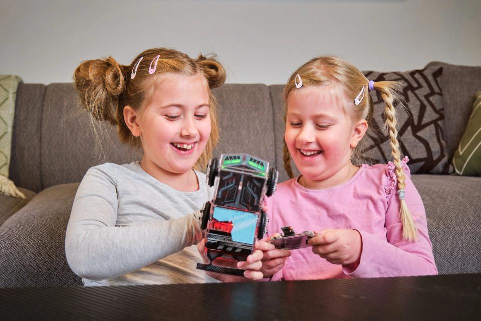 Two girls playing with CircuitMess Sparkly and its controller