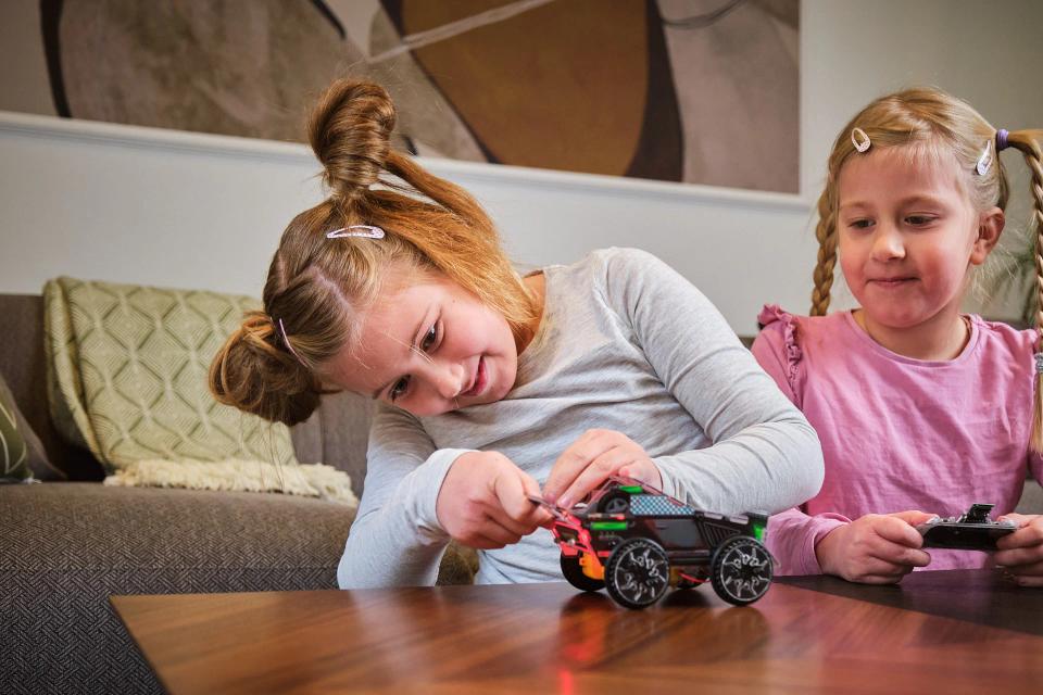 Two girls playing with CircuitMess Sparkly by using its controller