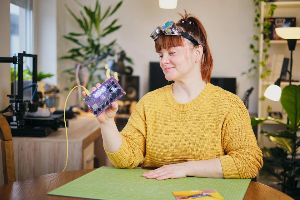 A woman holding a fully-built CircuitMess Synthia