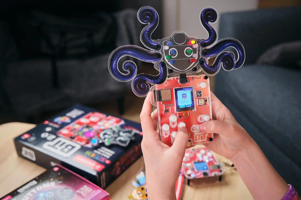 A person holding CircuitMess Bit with an Artemis robot attached to it