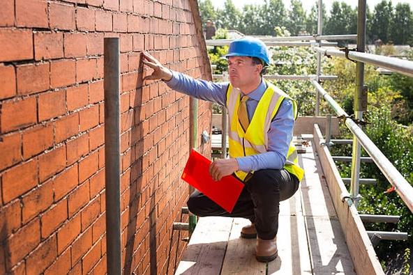 Surveyor assessing a gable wall