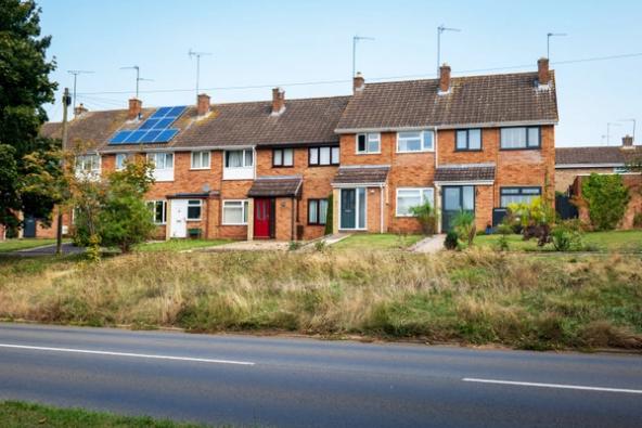 typical row of terraced housing with different replacement windows and some with solar panels on the roof